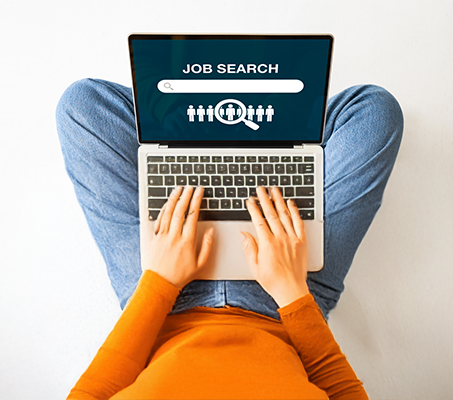 Person using a laptop with a job search screen displayed, including a search bar and job candidate icons.