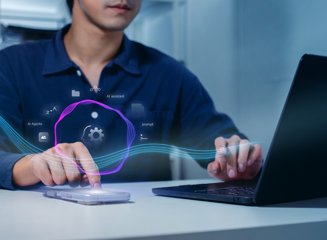 Person using a smartphone and laptop with digital icons representing AI assistants, agents, and prompts.