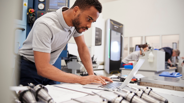 An engineer working on a computer with various parts scattered around a table