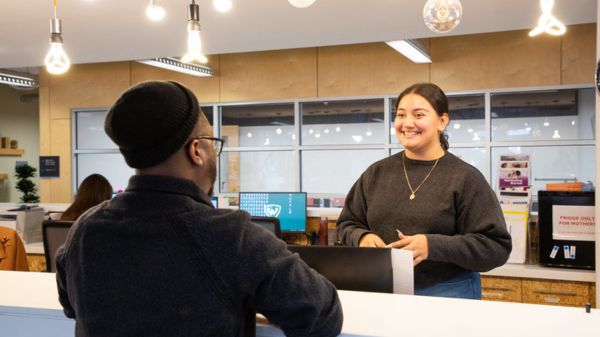 Two people mingling by an office's front desk