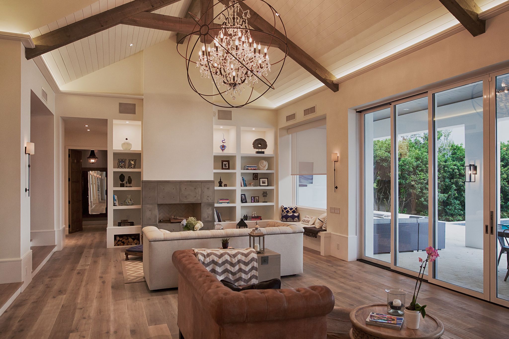Luxury living room with vaulted ceiling, chandelier, and motorized shades by Livewire
