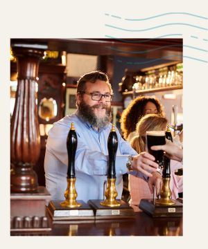 A friendly barman serving Guinness