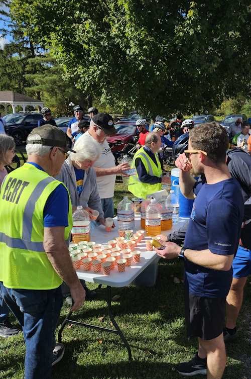 Image of volunteers giving drinks to cyclists.